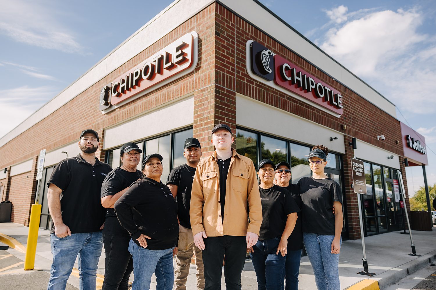 A Chipotle crew photographed together outside their restaurant.