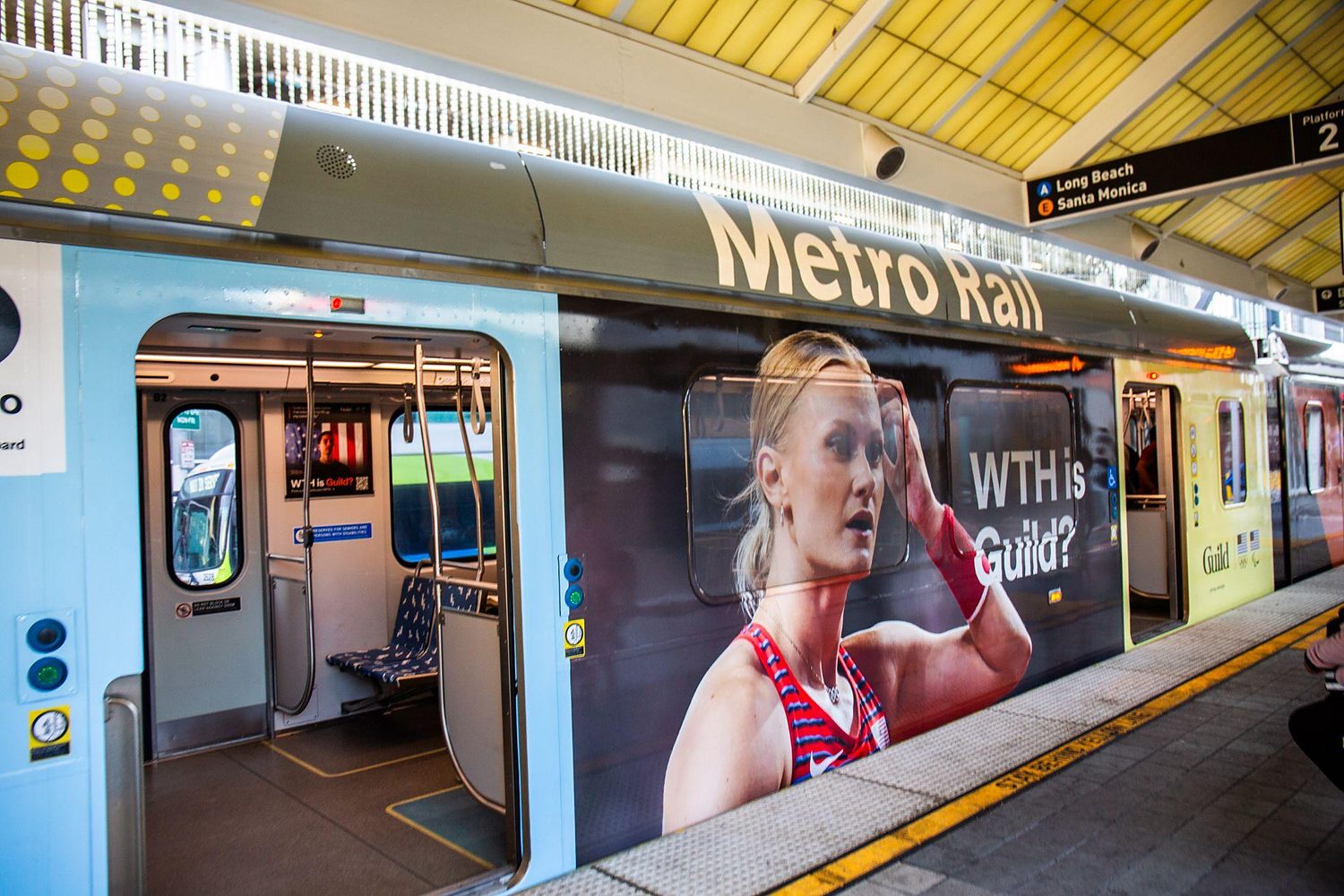 Metro Rail platform wrap featuring a Team USA athlete and the WTH is Guild? line.